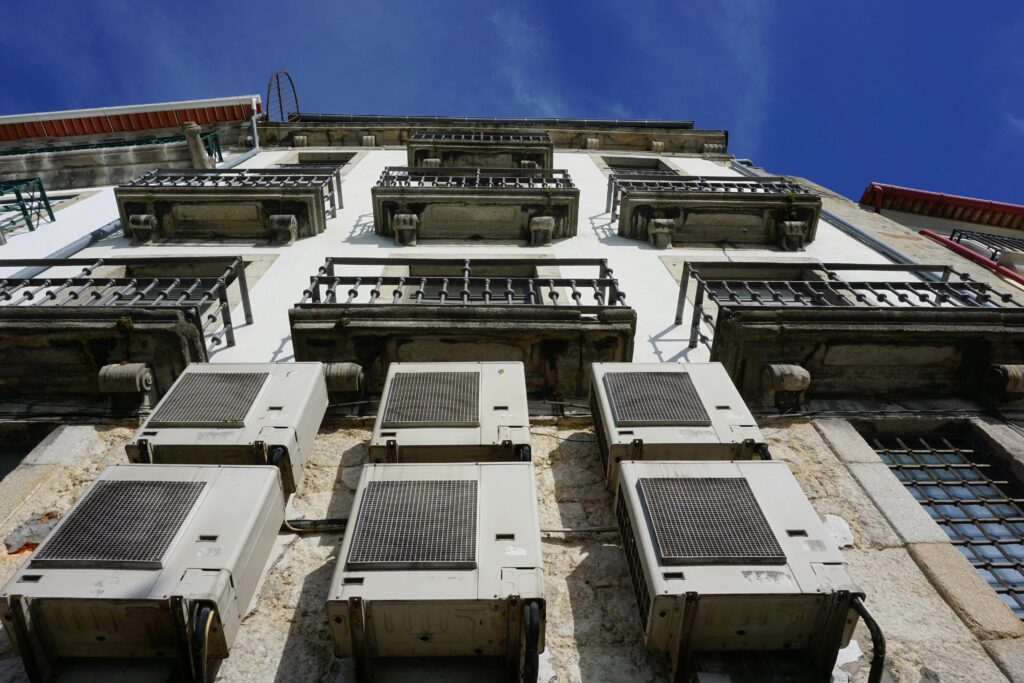 pexels photo 32230390 32230390 A upward view of a building facade with air conditioners and balconies in Porto.