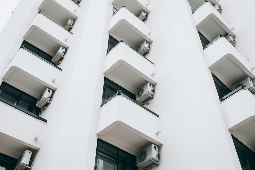 Low-angle view of a modern apartment facade with balconies in Kuşadası, Turkey.